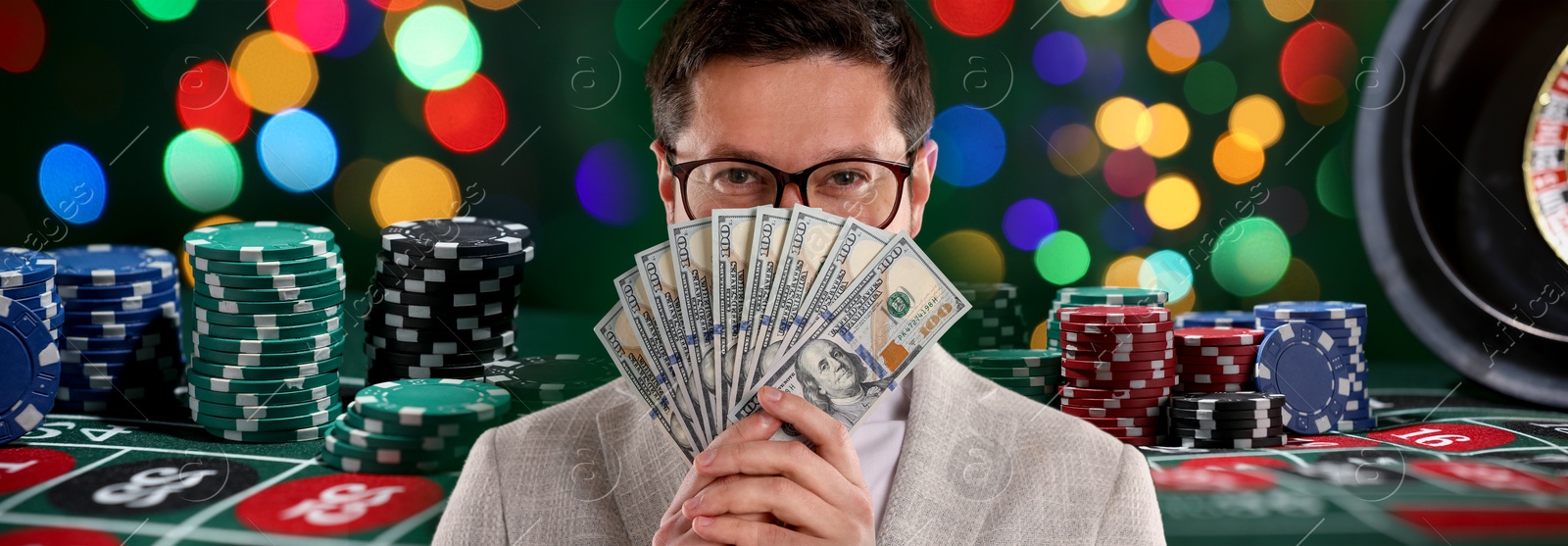 Gambler with money fan, casino chips and roulette table. Banner design Image of Gambler with money fan, casino chips and roulette table. Banner design