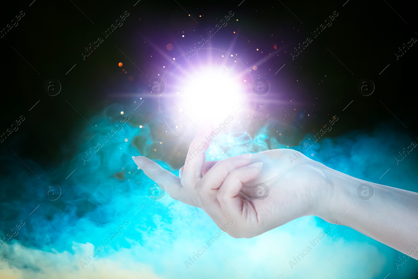 Woman creating bright light in smoke against black background, closeup. Aura, spiritual practice Image of Woman creating bright light in smoke against black background, closeup. Aura, spiritual practice