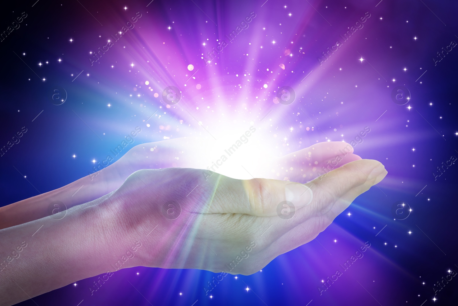 Image of Woman creating bright light against black background, closeup. Aura, spiritual practice