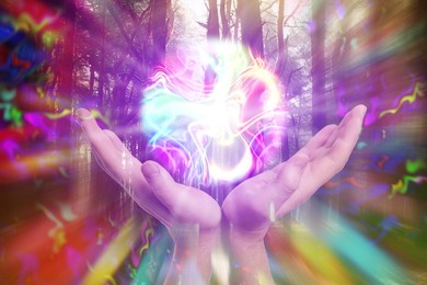 Image of Woman holding glowing iridescent sphere in forest, closeup. Aura, spiritual practice
