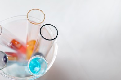 Photo of Solution chemistry. Test tubes with different samples on white table, top view. Space for text