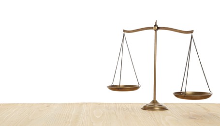 Photo of Golden scales of justice on wooden table against white background