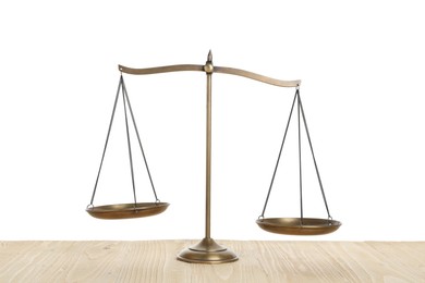 Photo of Golden scales of justice on wooden table against white background
