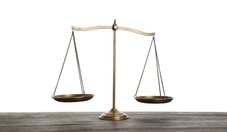Photo of Golden scales of justice on wooden table against white background