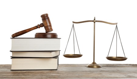 Photo of Golden scales of justice, books and gavel on wooden table against white background