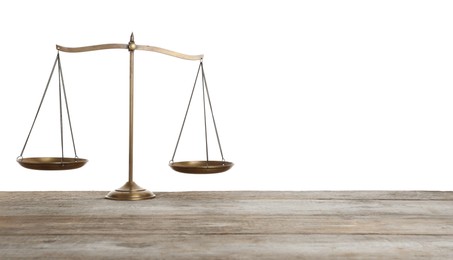Photo of Golden scales of justice on wooden table against white background