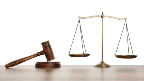 Photo of Golden scales of justice and gavel on wooden table against white background