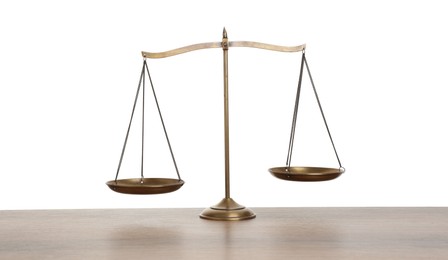 Photo of Golden scales of justice on wooden table against white background