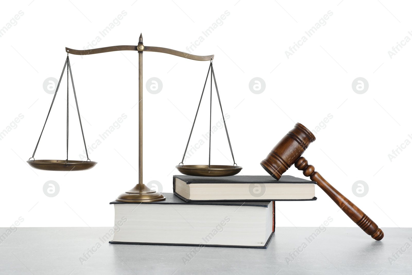 Photo of Golden scales of justice, books and gavel on light grey table against white background