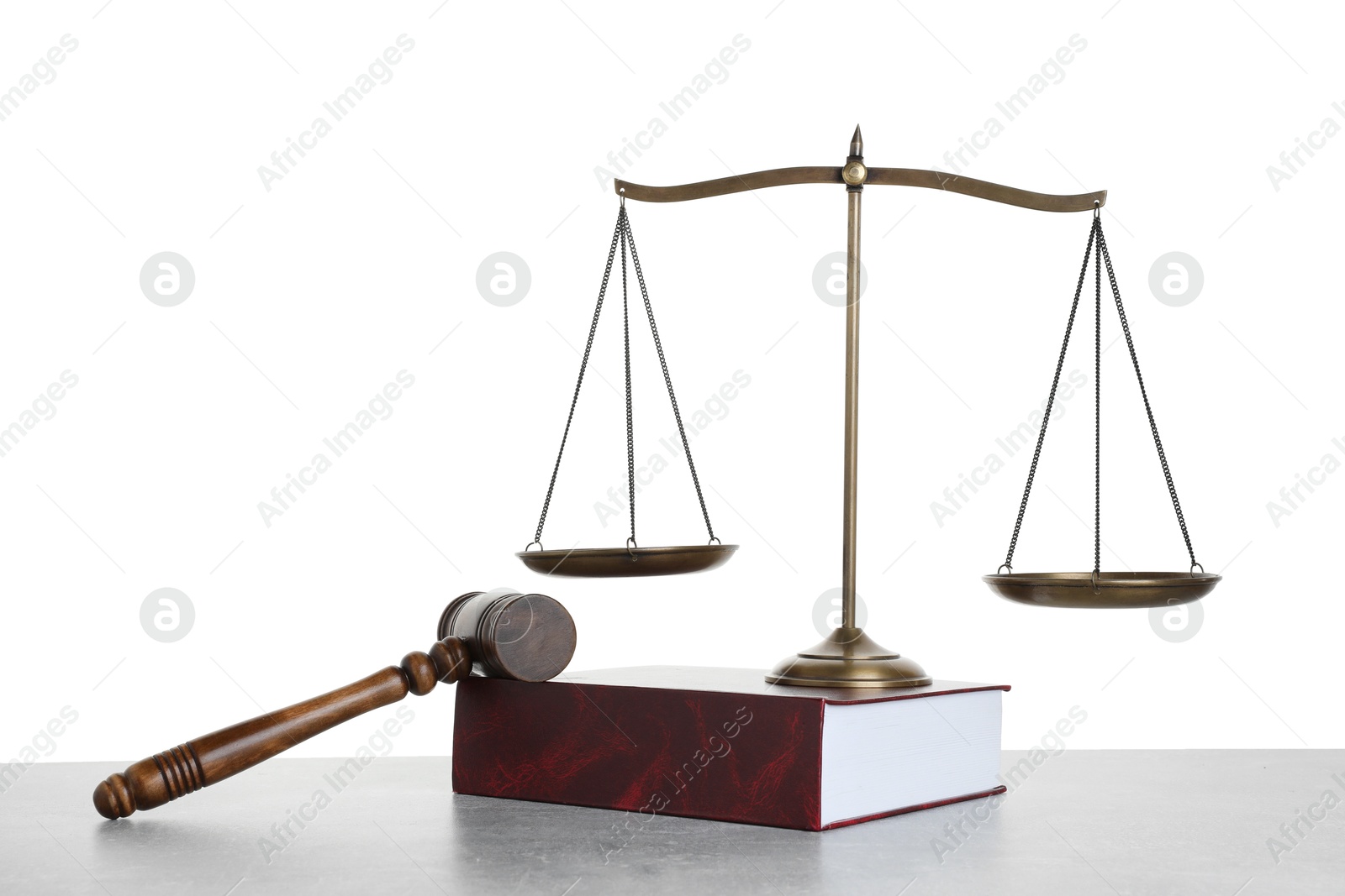 Photo of Golden scales of justice, book and gavel on light grey table against white background