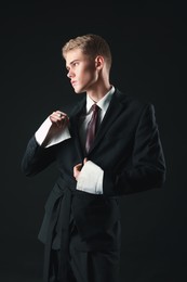 Photo of Handsome young man wearing stylish suit on black background