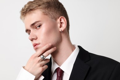 Photo of Handsome young man wearing stylish suit and ring on white background