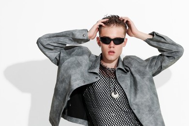 Photo of Handsome young man wearing stylish jacket and sunglasses on white background