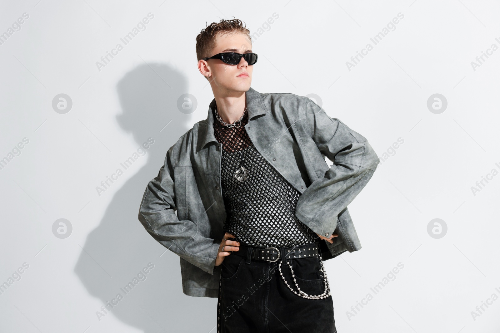 Photo of Handsome young man wearing stylish jacket and sunglasses on white background