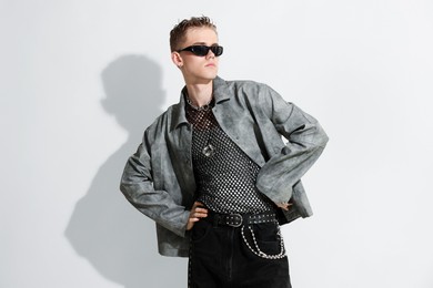 Photo of Handsome young man wearing stylish jacket and sunglasses on white background