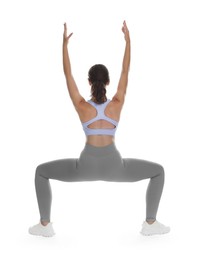 Photo of Teenage girl in sportswear stretching on white background, back view