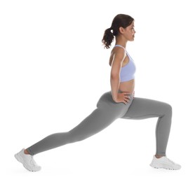 Photo of Teenage girl in sportswear stretching on white background