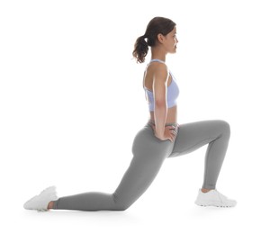 Photo of Teenage girl in sportswear stretching on white background