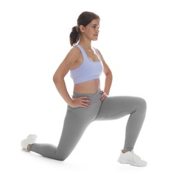 Photo of Teenage girl in sportswear stretching on white background