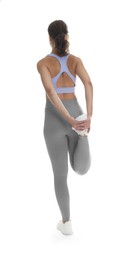 Photo of Teenage girl in sportswear stretching on white background, back view