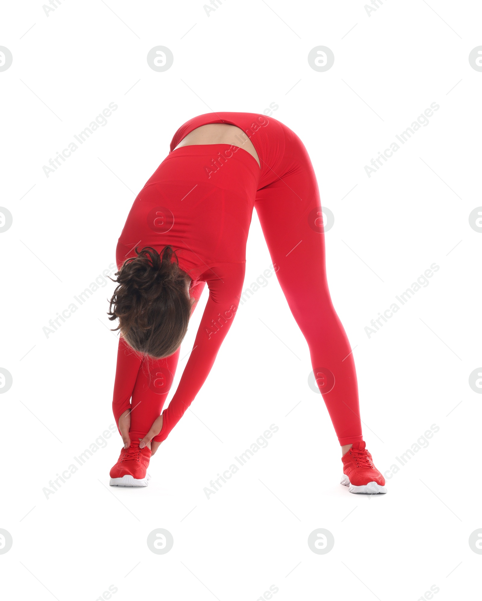 Photo of Teenage girl in sportswear stretching on white background