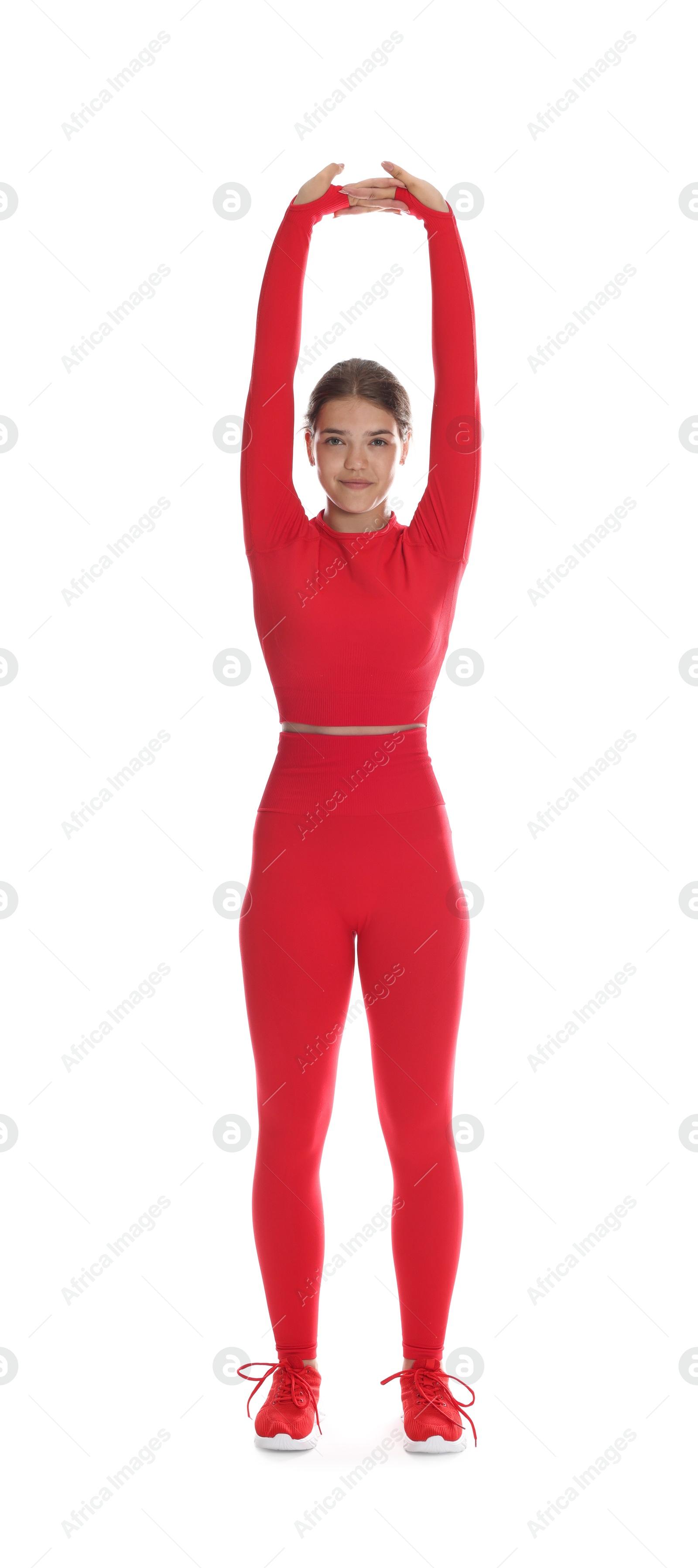 Photo of Teenage girl in sportswear stretching on white background