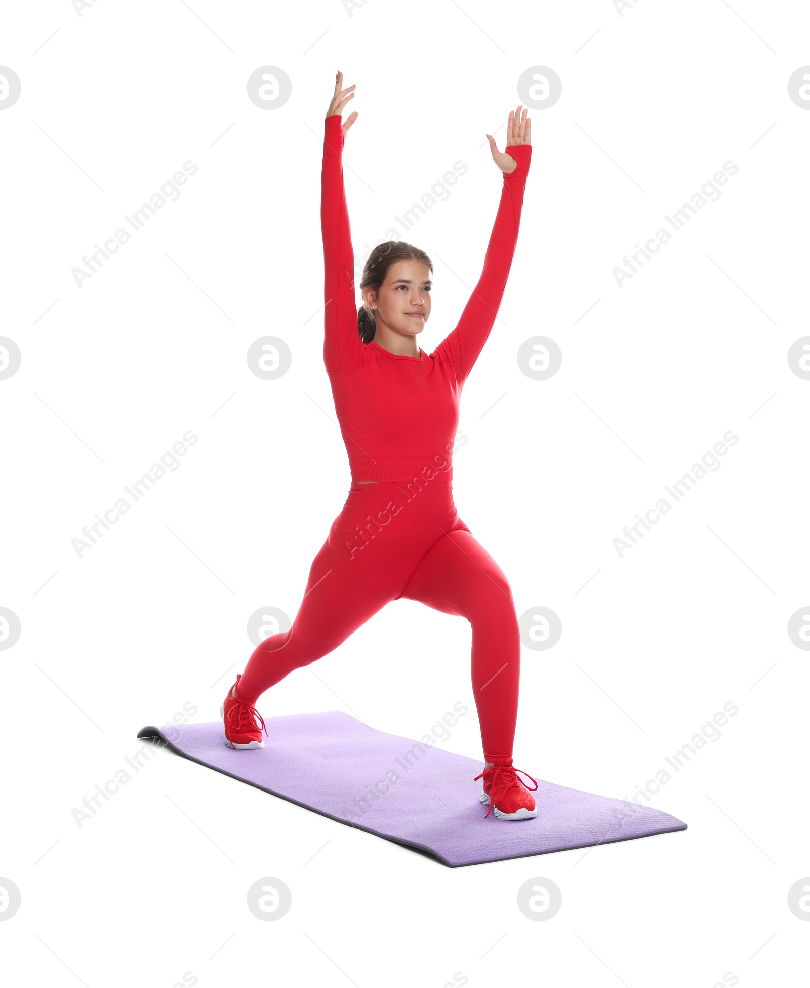 Photo of Teenage girl in sportswear stretching on mat against white background