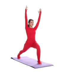 Photo of Teenage girl in sportswear stretching on mat against white background