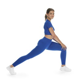 Photo of Teenage girl in sportswear stretching on white background