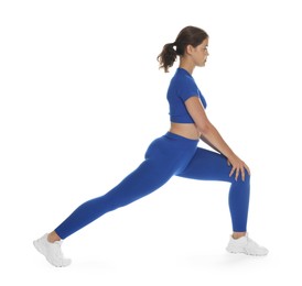 Photo of Teenage girl in sportswear stretching on white background