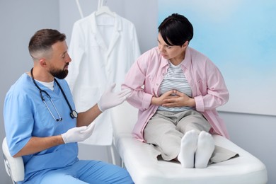 Photo of Gastroenterologist consulting patient with stomach pain in clinic