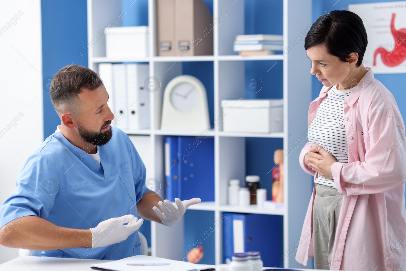 Gastroenterologist consulting patient with stomach pain in clinic Photo of Gastroenterologist consulting patient with stomach pain in clinic