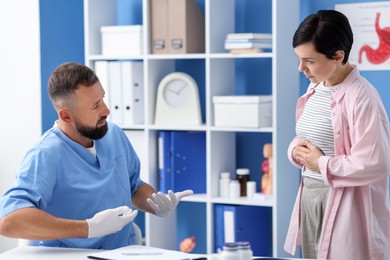 Photo of Gastroenterologist consulting patient with stomach pain in clinic