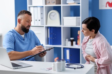 Photo of Gastroenterologist consulting patient with stomach pain in clinic