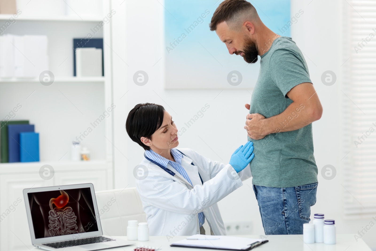 Gastroenterologist examining patient with stomach pain in clinic Photo of Gastroenterologist examining patient with stomach pain in clinic