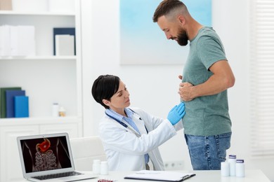 Photo of Gastroenterologist examining patient with stomach pain in clinic