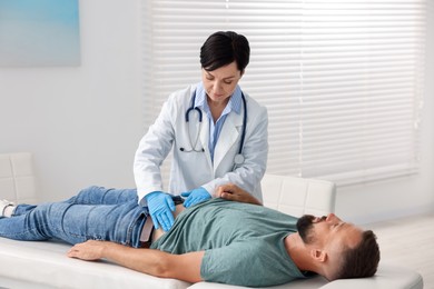 Photo of Gastroenterologist examining patient with stomach pain in clinic