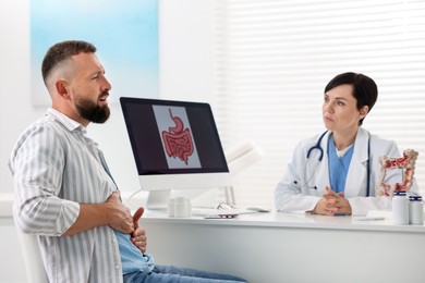 Photo of Gastroenterologist consulting patient with stomach pain in clinic