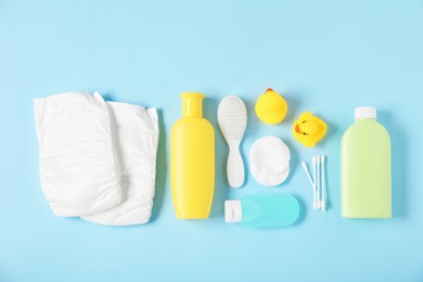 Photo of Baby accessories and cosmetic products on light blue background, flat lay