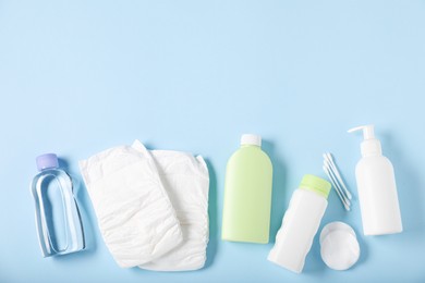 Photo of Baby accessories and cosmetic products on light blue background, flat lay. Space for text