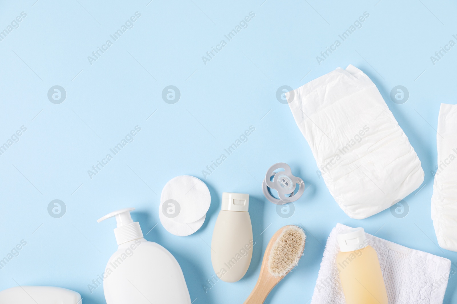 Photo of Baby accessories and cosmetic products on light blue background, flat lay. Space for text