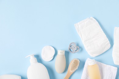 Photo of Baby accessories and cosmetic products on light blue background, flat lay. Space for text