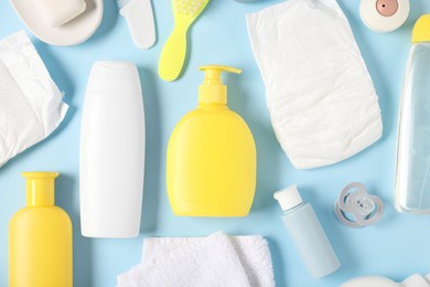 Photo of Baby accessories and cosmetic products on light blue background, flat lay