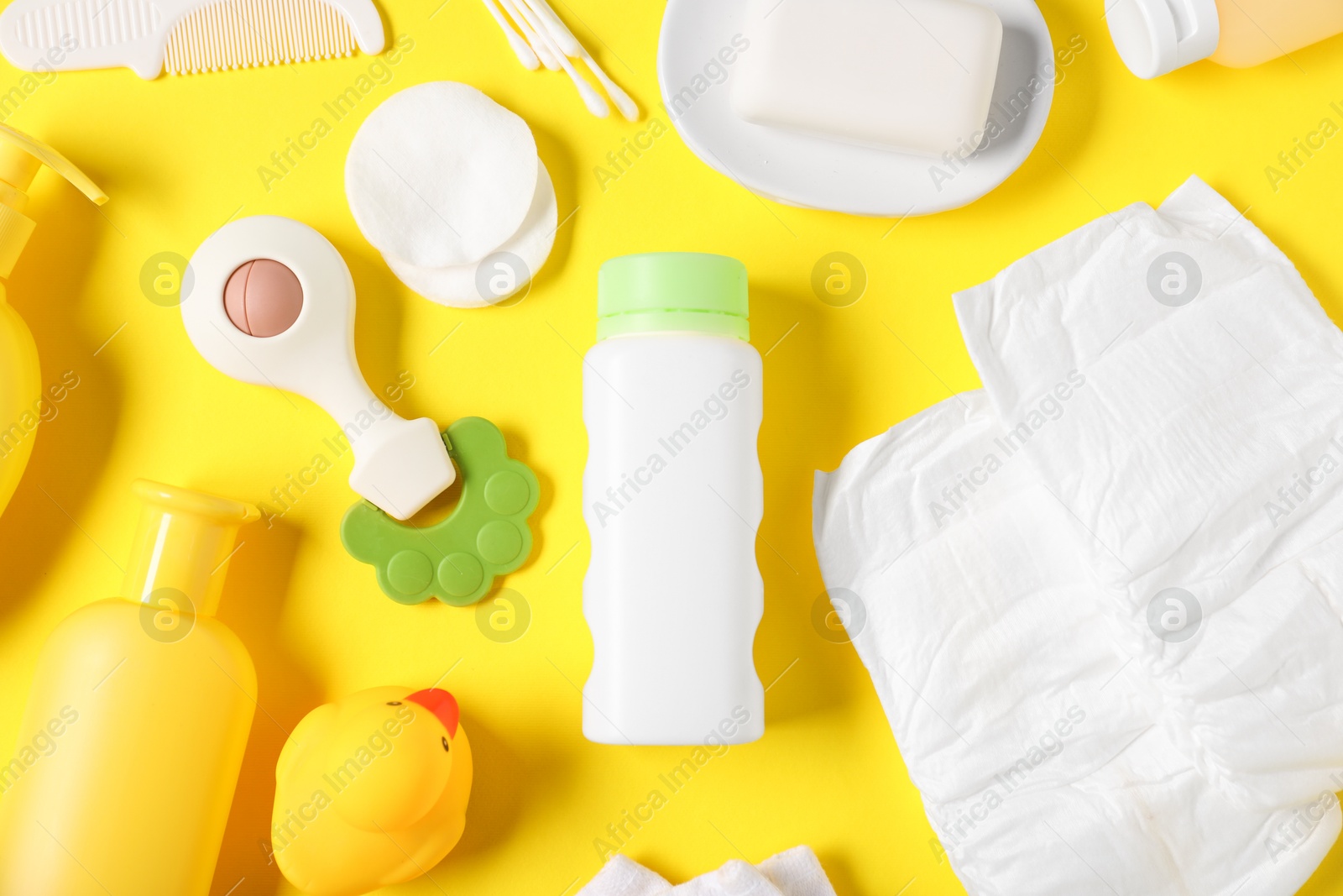 Baby accessories and cosmetic products on yellow background, flat lay Photo of Baby accessories and cosmetic products on yellow background, flat lay