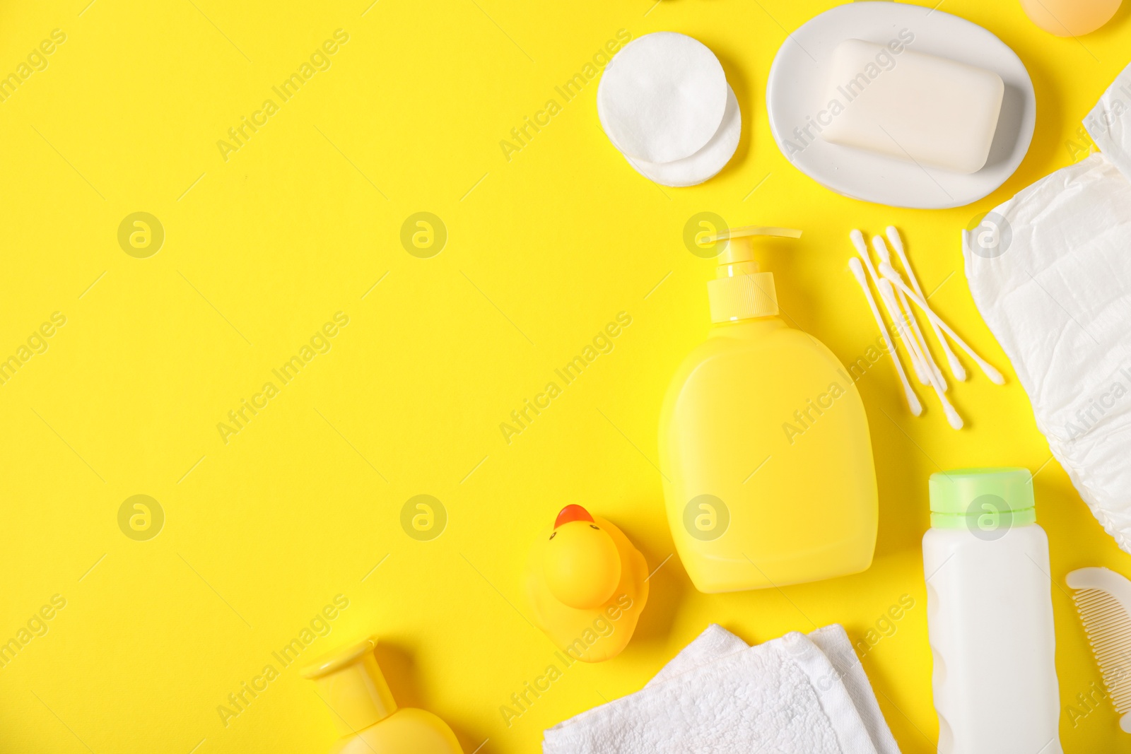 Baby accessories and cosmetic products on yellow background, flat lay. Space for text Photo of Baby accessories and cosmetic products on yellow background, flat lay. Space for text