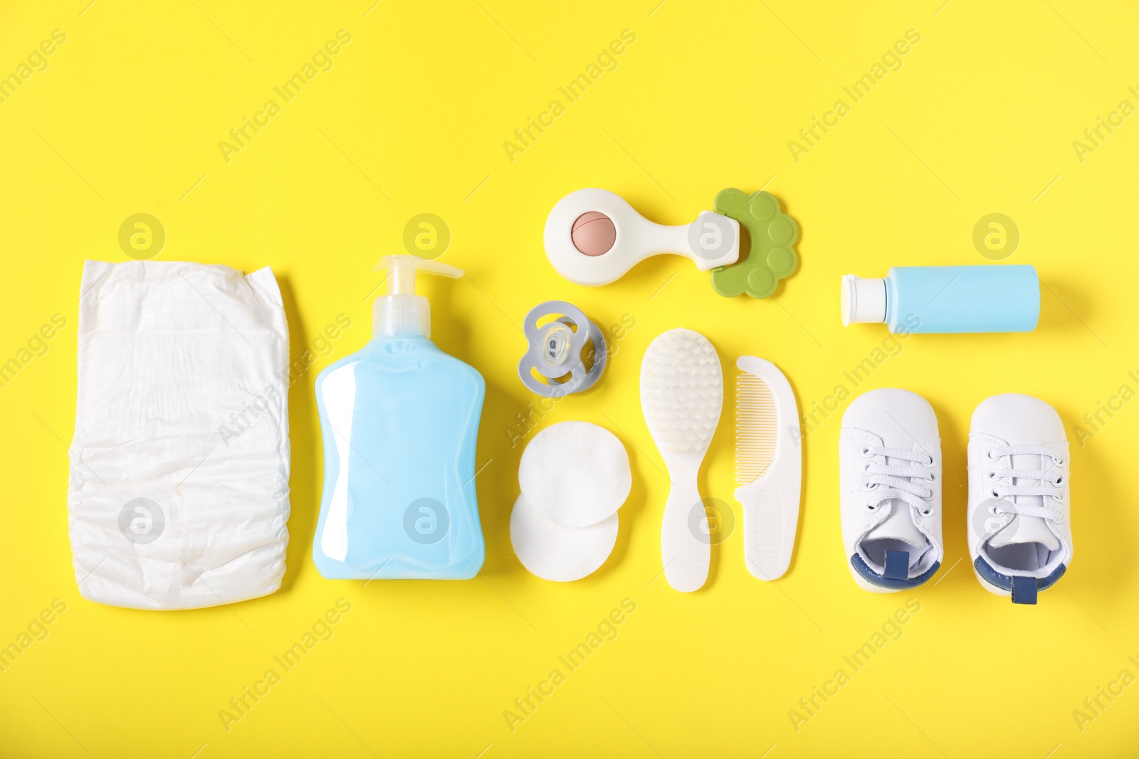 Baby accessories and cosmetic products on yellow background, flat lay Photo of Baby accessories and cosmetic products on yellow background, flat lay