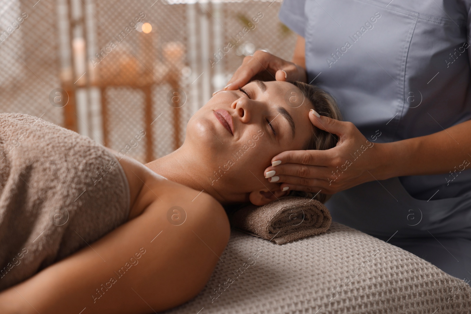 Beautiful woman receiving facial massage on couch in spa salon, closeup Photo of Beautiful woman receiving facial massage on couch in spa salon, closeup