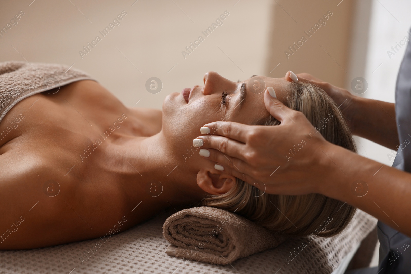 Beautiful woman receiving facial massage on couch in spa salon, closeup Photo of Beautiful woman receiving facial massage on couch in spa salon, closeup
