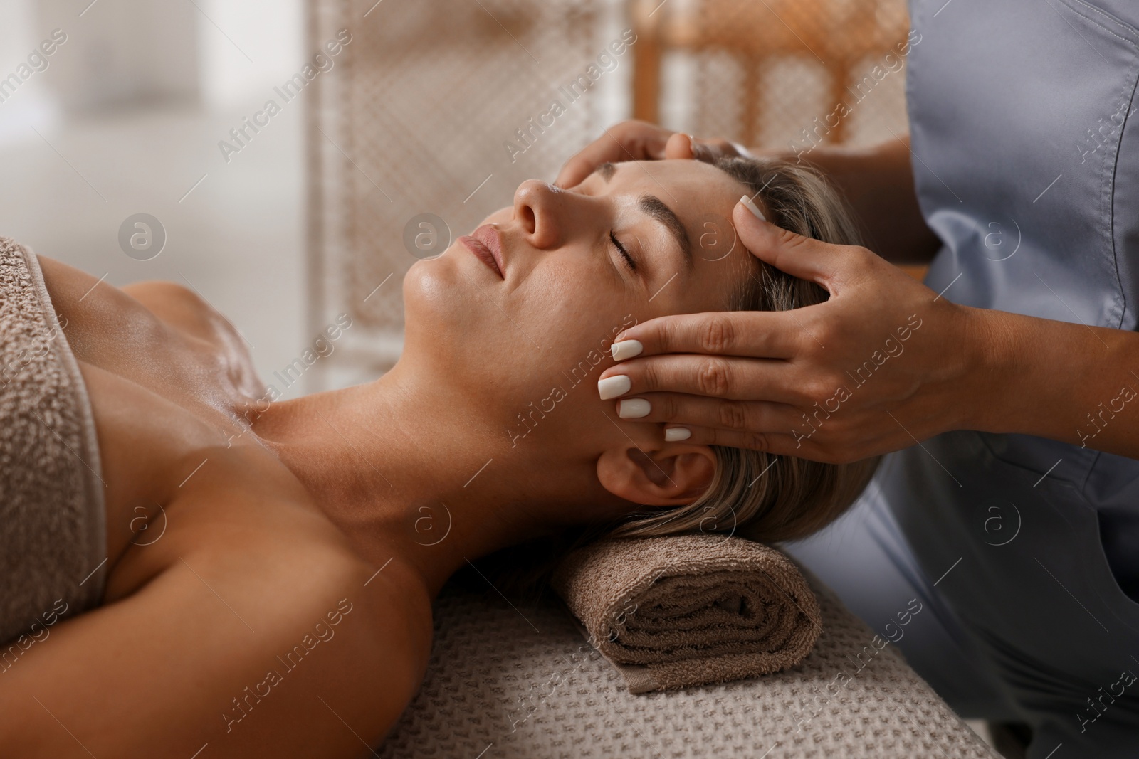 Beautiful woman receiving facial massage on couch in spa salon, closeup Photo of Beautiful woman receiving facial massage on couch in spa salon, closeup