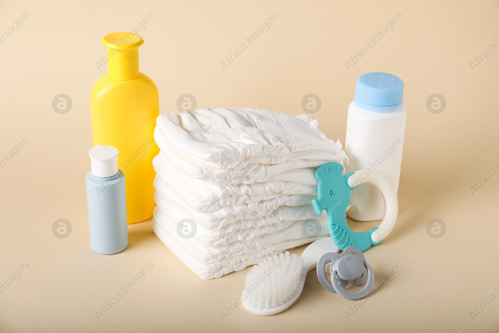 Baby accessories and cosmetic products on beige background Photo of Baby accessories and cosmetic products on beige background